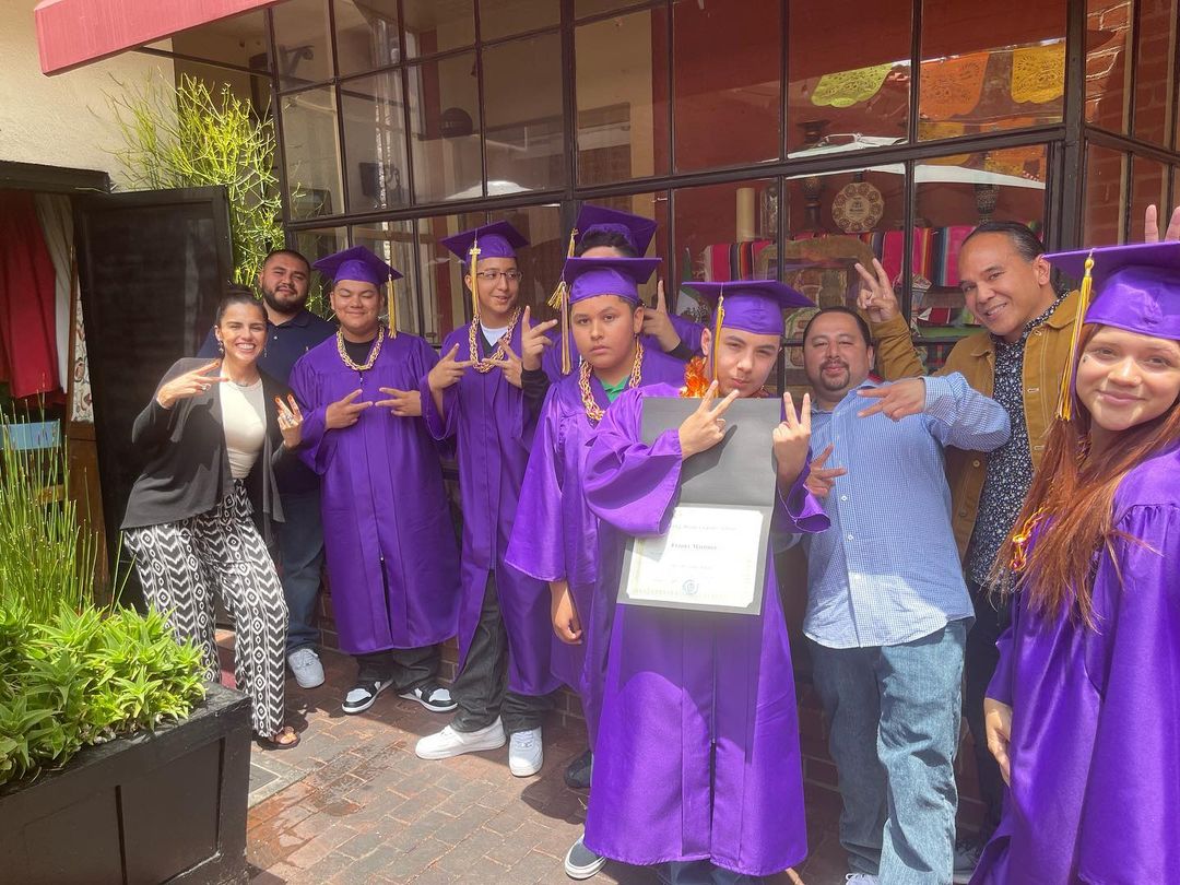 Group of Learning Works graduates in their purple caps and gowns.